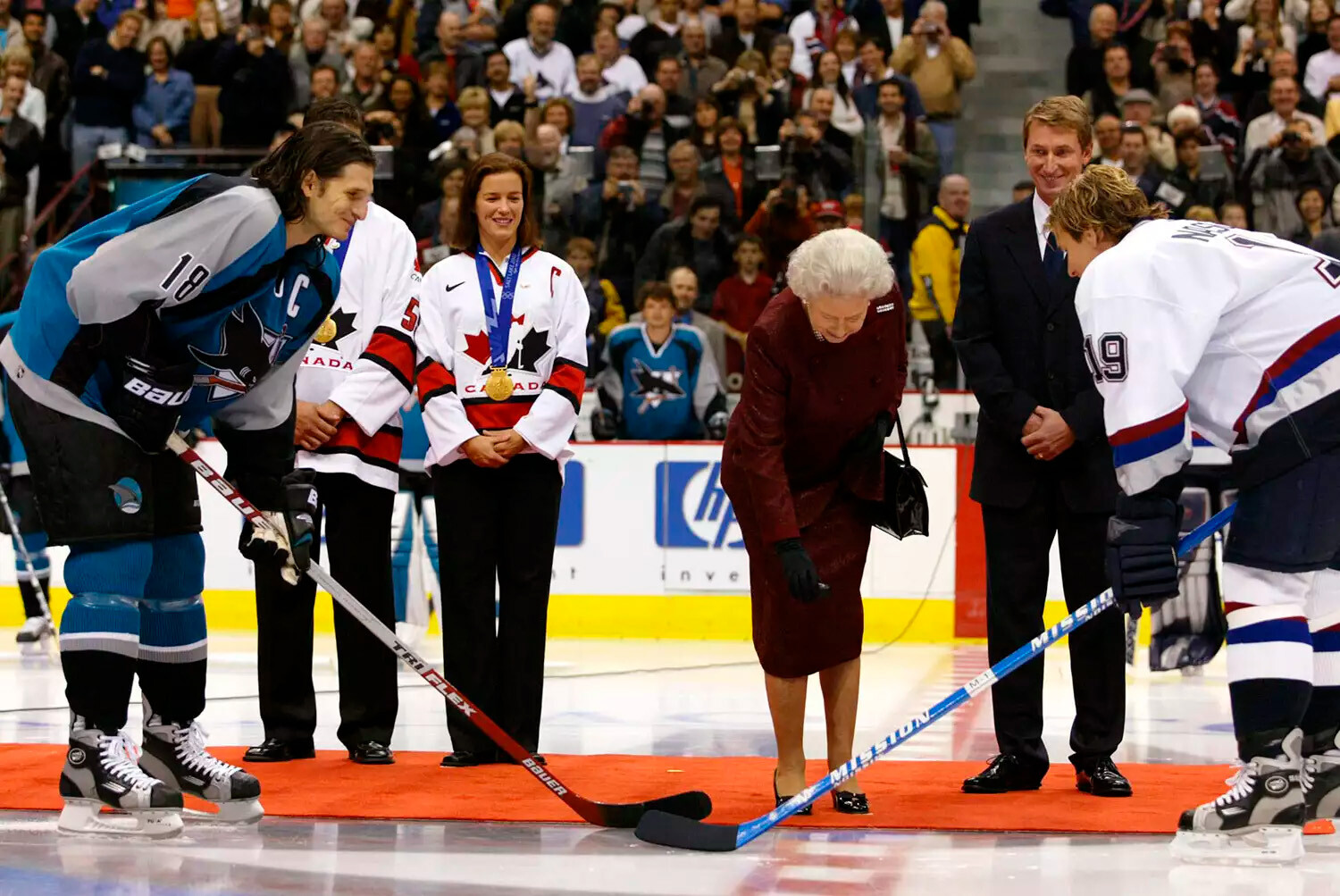 Королева Елизавета II получает церемониальную шайбу, подаренную ей бывшим &laquo;Эдмонтон Ойлерз&raquo; и генеральным менеджером мужской олимпийской хоккейной команды Уэйном Гретцки 6 октября 2002 года в Ванкувере, Канада