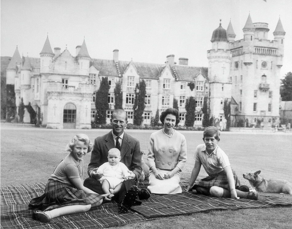 Маленький принц Эндрю сидит на коленях у принца Филиппа во время пикника на территории замка Балморал. Также на фото королева Елизавета, принц Чарльз и принцесса Анна, 1960&nbsp;&nbsp;г.