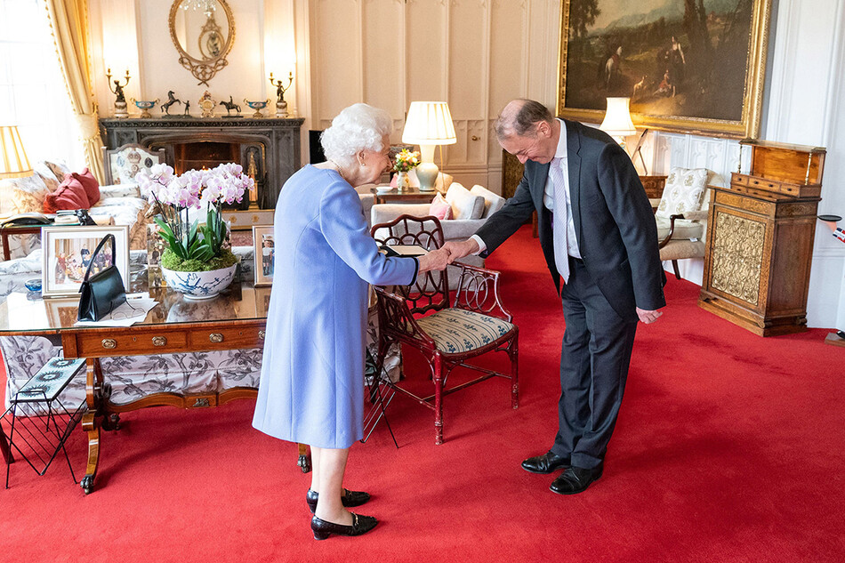 Королева Елизавета II вручает Томасу Троттеру медаль королевы за вклад в музыку в Виндзорском замке 8 декабря 2021 года в Виндзоре, Англия