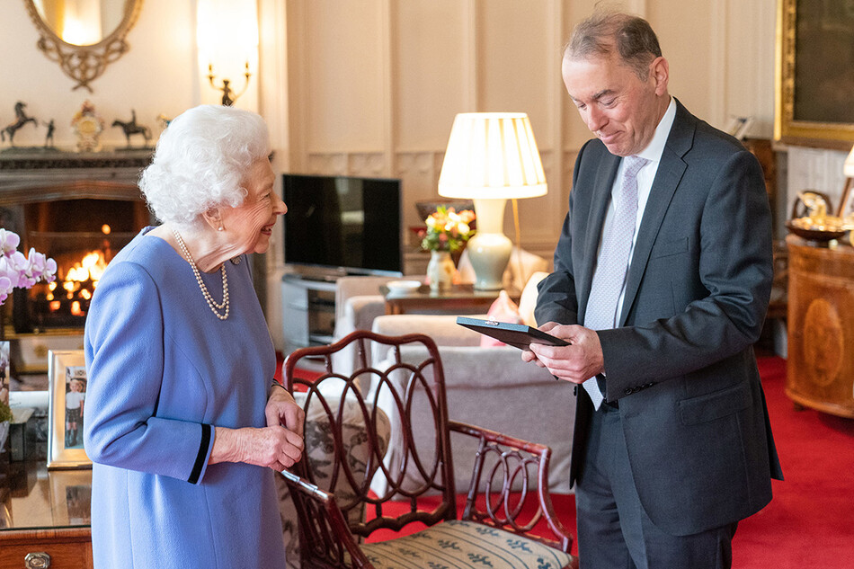 Королева Елизавета II вручает Томасу Троттеру медаль королевы за вклад в музыку в Виндзорском замке 8 декабря 2021 года в Виндзоре, Англия