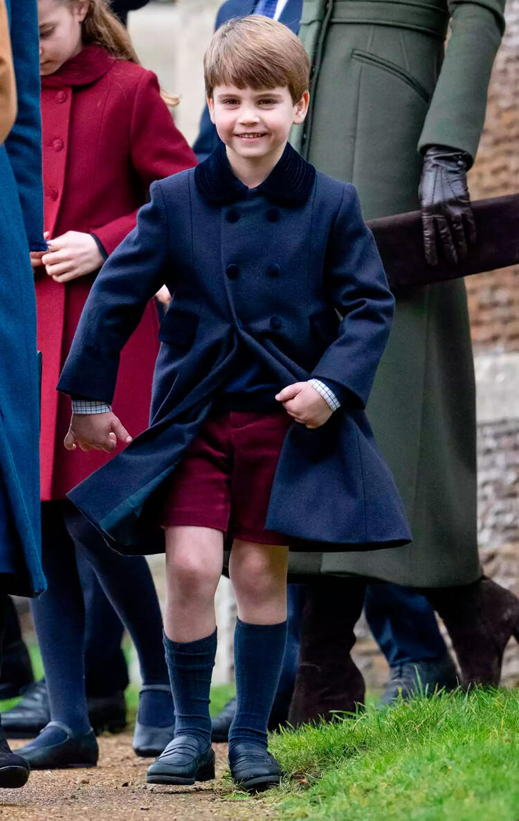 Луи, принц Уэльский демонстрирует королевским фанатам свои красные шорты во время дебютного посещения рождественской службы в Сандрингемской церкви 25 декабря 2022 года, Норфолк