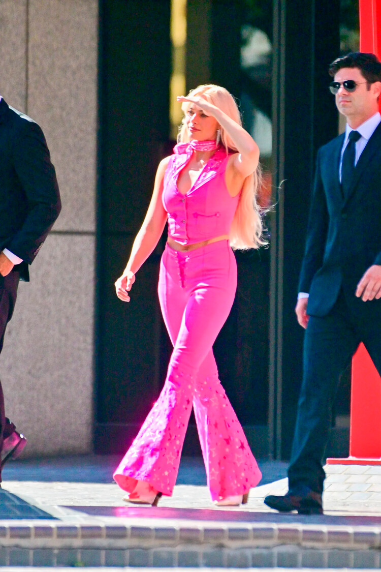 Марго Робби в розовом костюме, состоящим из укороченной жилетки и брюк-клёш, 2022