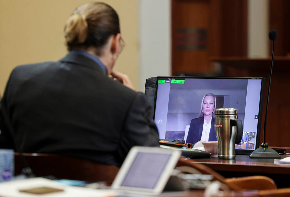 Джонни Депп слушает, как его бывшая девушка, модель Кейт Мосс, даёт показания по видеосвязи во время судебного процесса по делу о клевете против его бывшей жены Эмбер Херд в окружном суде округа Фэрфакс в Фэрфаксе, штат Вирджиния, 25 мая 2022 года