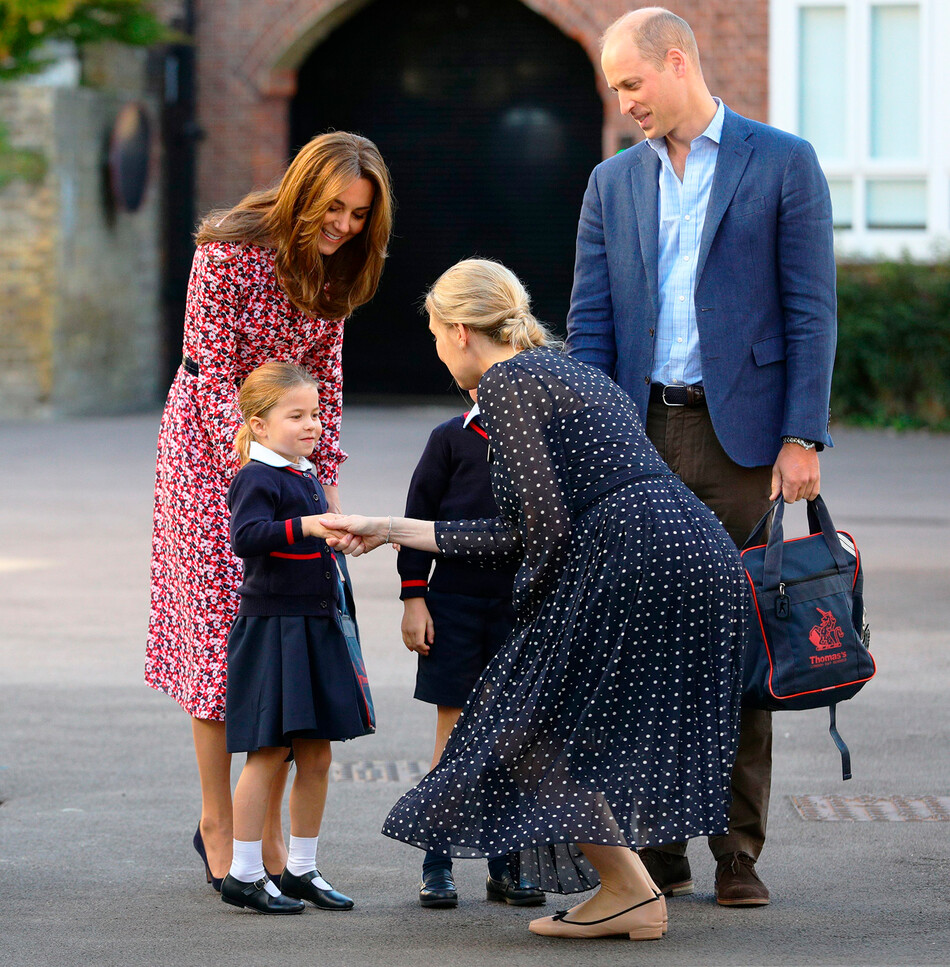 Хелен Хаслем, директор младшей школы приветствует принцессу Шарлотту и её брата принца Джорджа в первый день в школе Баттерси Томаса в Лондоне 5 сентября 2019 года в Лондоне