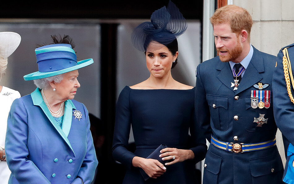 Королева Елизавета II, Меган, герцогиня Сассекская и принц Гарри, герцог Сассекский, наблюдают за парадом, посвященным столетию королевской семьи с балкона Букингемского дворца 10 июля 2018 года в Лондоне, Англия