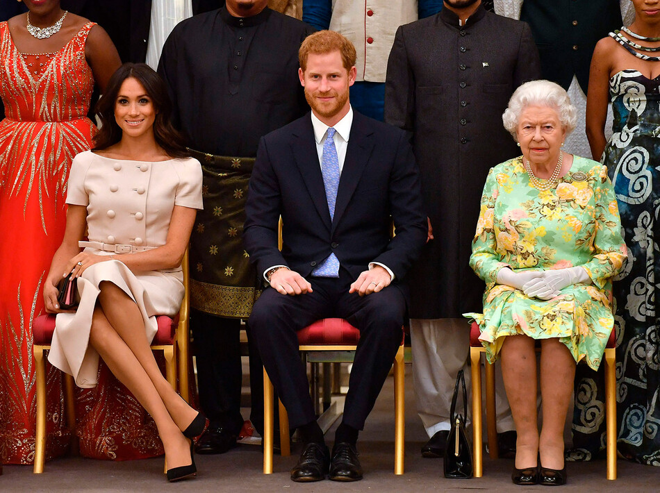 Меган Маркл, принц Гарри, герцог Сассекский и королева Елизавета II позируют фотографу во время церемонии награждения молодых лидеров королевы 26 июня 2018 года в Букингемском дворце в Лондоне