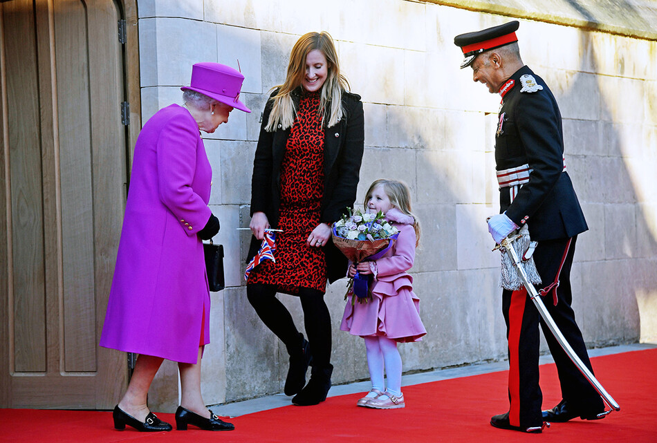 Королева Елизавета II получает букет от Иви Хайден (4 лет) и ее матери Мишель во время ее визита в Почетное общество Lincoln's Inn в Lincoln's Inn 13 декабря 2018 года в Лондоне, Великобритания