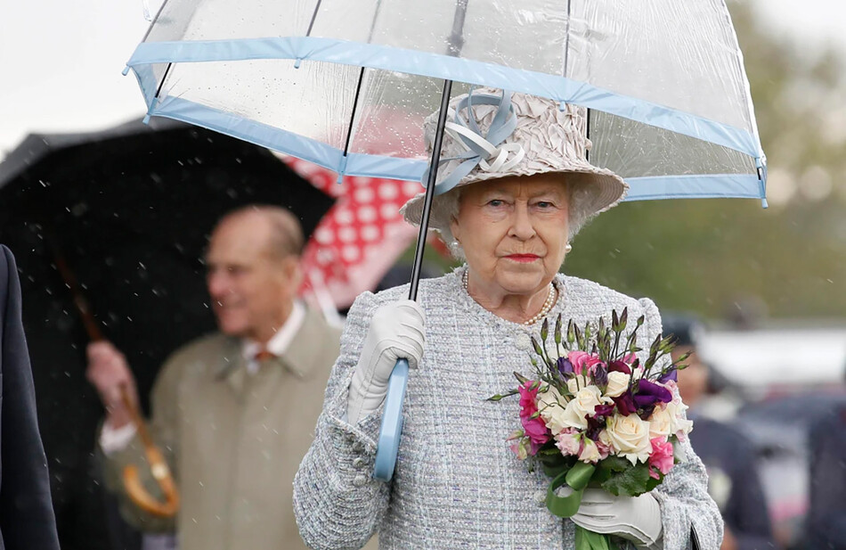 Королева Елизавета II прячется под зонтиком во время посещения выставки &laquo;Дикий Лондон&raquo; с принцем Филиппом, герцогом Эдинбургским, 15 мая 2012 года в Ричмонде, Англия
