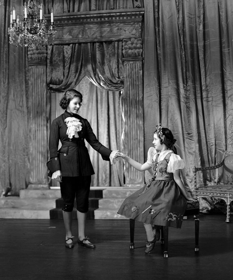 Королева Елизавета II в образе очаровательного принца с принцессой Маргарет в образе Золушки во время королевской пантомимы в Виндзорском замке, 1941