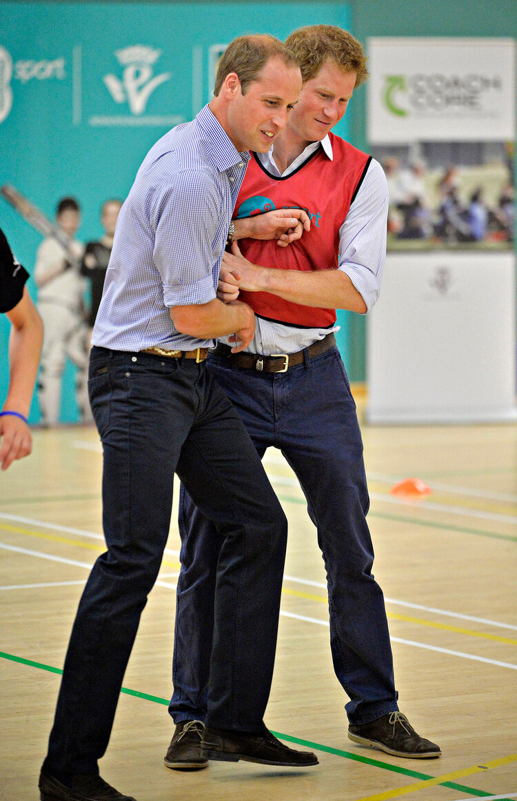 Принц Гарри и принц Уильям играют в футбол во время посещения проекта Coach Core в развлекательном центре Gorbals 29 июля 2014 года в Глазго, Шотландия