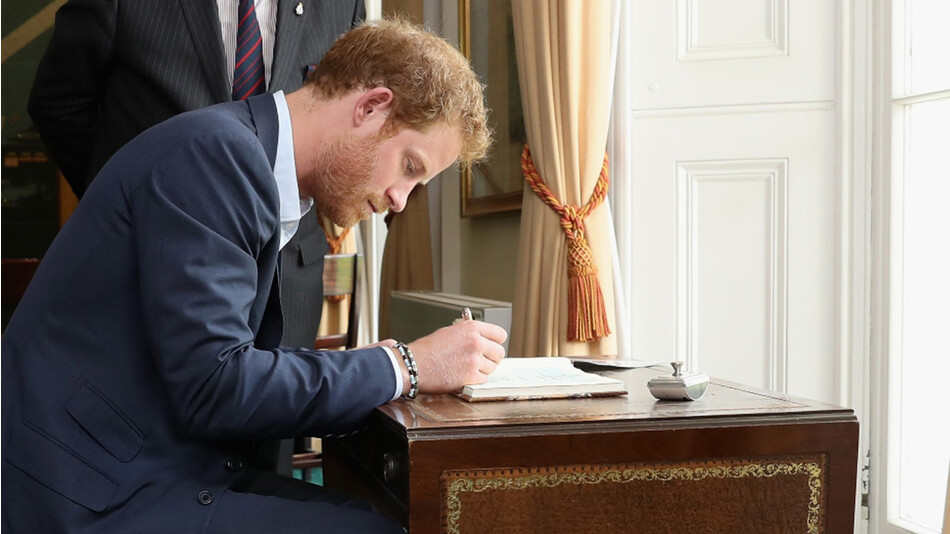 Принц Гарри подписывает книгу посещений на приёме в честь ветеранов Нормандии в Саутвик-Хаусе 2 июня 2016 года в Портсмуте, Англия