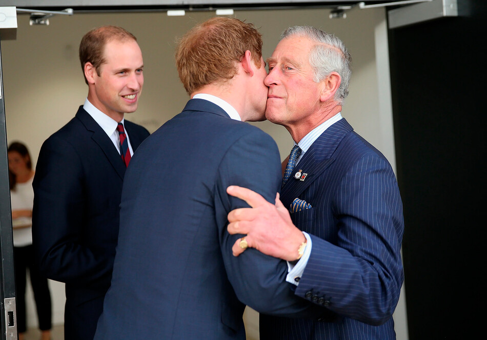 Принц Чарльз приветствует своего сына принца Гарри, под пристальным взоров принц а Уильяма перед церемонией открытия игр Invictus Games в парке королевы Елизаветы II 10 сентября 2014 года в Лондоне, Англия
