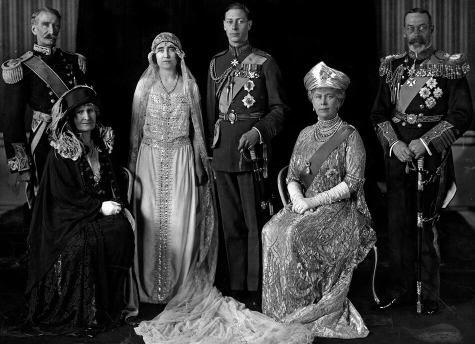 Альберт и Елизавета, герцог и герцогиня Йоркские (будущие король Англии Георг VI и королева Елизавета) в день свадьбы. Слева от пары сидят родители невесты Клод и Сесилия Боуз-Лайон, граф и графиня Стратмор, а справа от них родители жениха, король Англии Георг, 26 апреля 1923 года&nbsp;