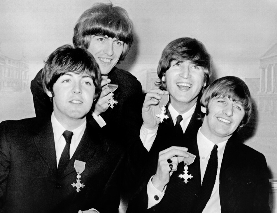 The Beatles демонстрируют медали, которые они получили, когда королева Елизавета пожаловала им членство в Ордене Британской империи в Букингемском дворце, 1965