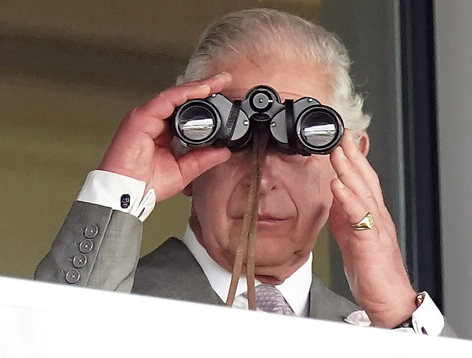 Принц Чарльз, принц Уэльский, наблюдает за гонками (в бинокль), из королевской ложи во второй день королевских скачек Royal Ascot на ипподроме Аскот в июне 14 февраля 2022 года в Аскоте, Англия
