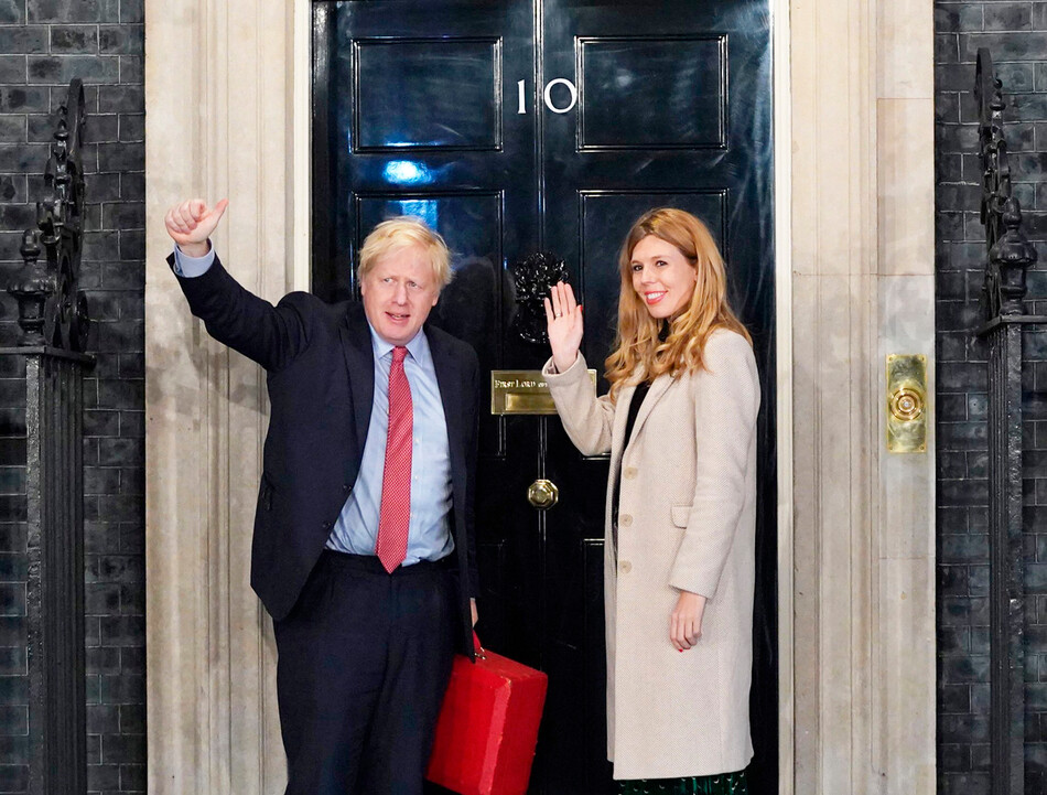 Премьер-министр Борис Джонсон с будущей женой Кэрри Саймондс выходят из двери Даунинг-стрит 10 в Лондоне 13 декабря 2019 года, Англия