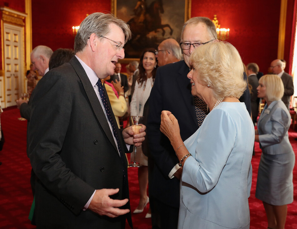 Камилла, герцогиня Корнуольская беседует с королевским историком Робертом Хардманом на вечеринке в честь 30-летия Национального общества остеопороза в Сент-Джеймсском дворце 12 июля 2016 года в Лондоне, Англия