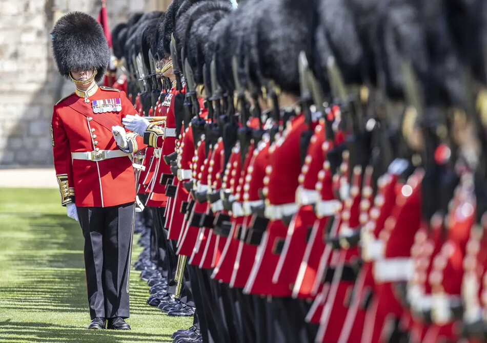 Уорент-офицер 1-го батальона ирландской гвардии следит за тем, чтобы шеренга королевских гвардейцев была прямой, во время парадного построения в честь вручения принцем Уильямом новых знамён полка в Виндзорском замке, в Виндзоре, 17 мая 2022 года