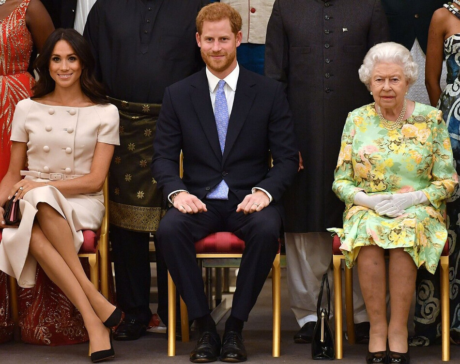 Меган и принц Гарри вместе с королевой Великобритании Елизаветой II  во время церемонии награждения молодых лидеров королевы 26 июня 2018 года в Букингемском дворце в Лондоне