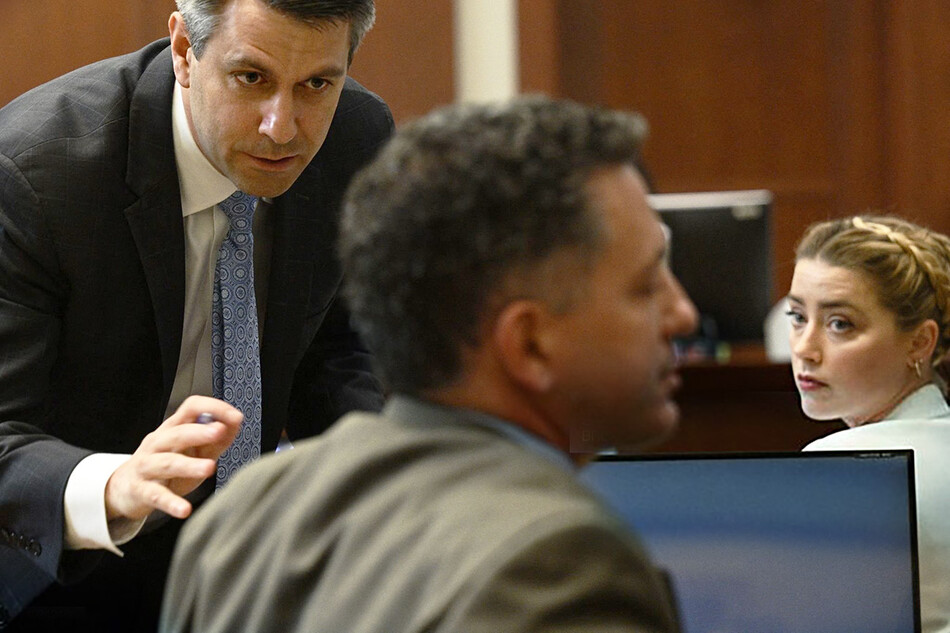 Эмбер Херд смотрит на своего адвоката Бена Роттенборна (слева) в зале окружного суда округа Фэрфакс в Фэрфаксе, штат Вирджиния, 26 апреля 2022 года