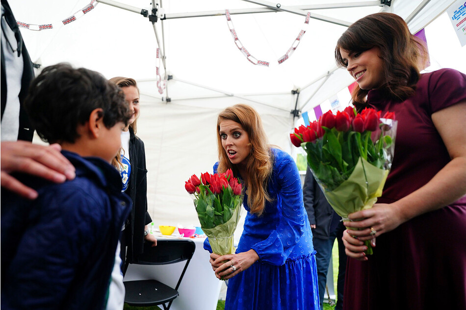 Принцессе Беатрис (в центре) и принцессе Евгении дарят цветы, во время прибытия на Большой юбилейный обед, организованный Вестминстерским советом для местных волонтеров и общественных групп, которые помогали во время пандемии Covid-19, в четвертый день празднование Платинового Юбилея, 5 июня 2022 года
