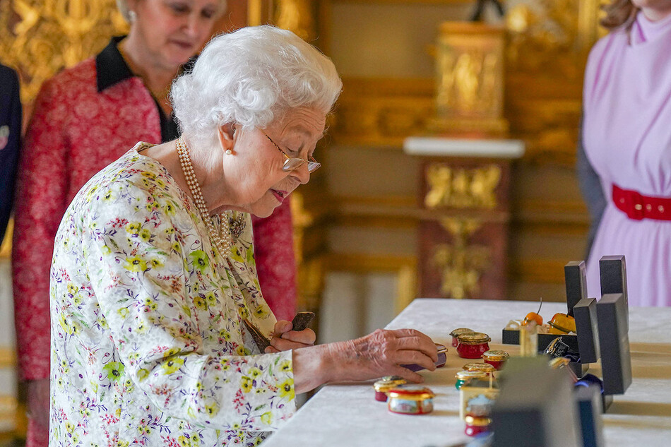 Королева Великобритании изучает процесс изготовления изделия