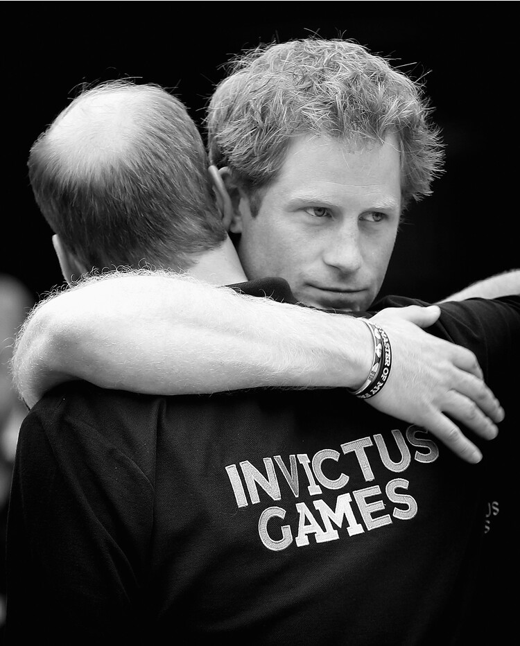 Принц Уильям и его брат принц Гарри обнимаются, когда герцог Кембриджский покидает соревнования по легкой атлетики во время проведения игр Invictus Games 11 сентября 2014 года в Лондоне, Англия