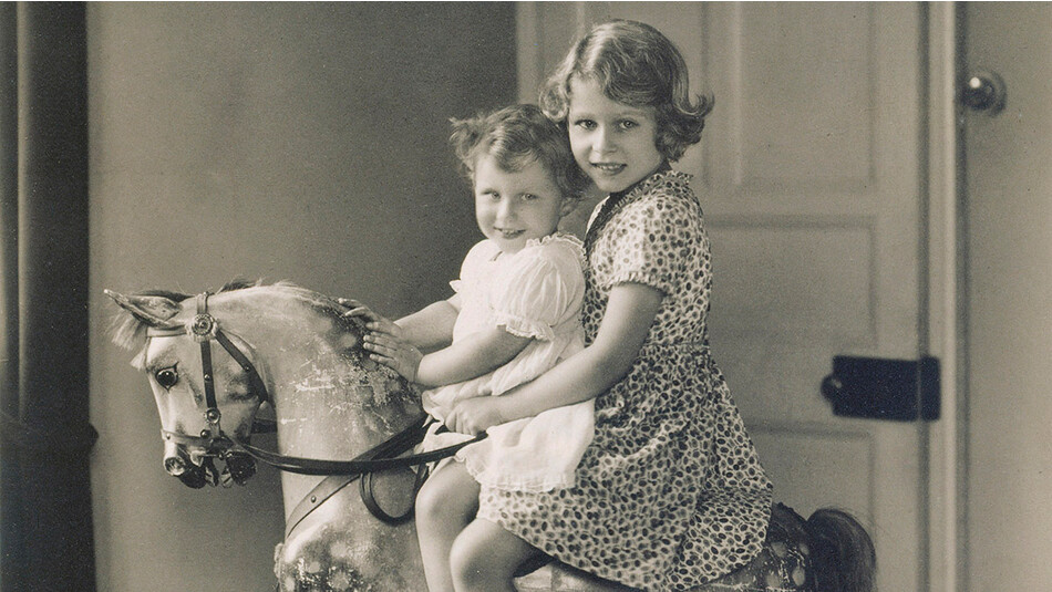 Принцессы Елизавета (будущая Елизавета II) и её сестра Маргарет верхом на игрушечном коне, 1932