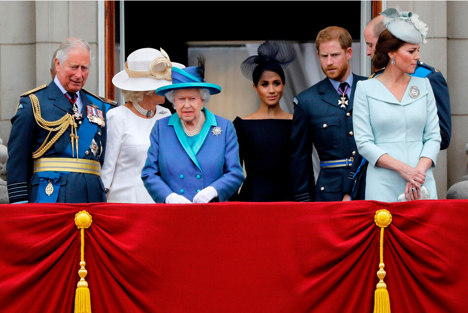 Королева Елизавета II, Меган Маркл с принцем Гарри и другими членами королевской семьи наблюдают за парадом, посвящённым столетию королевских ВВС с балкона Букингемского дворца 10 июля 2018 года в Лондоне, Англия