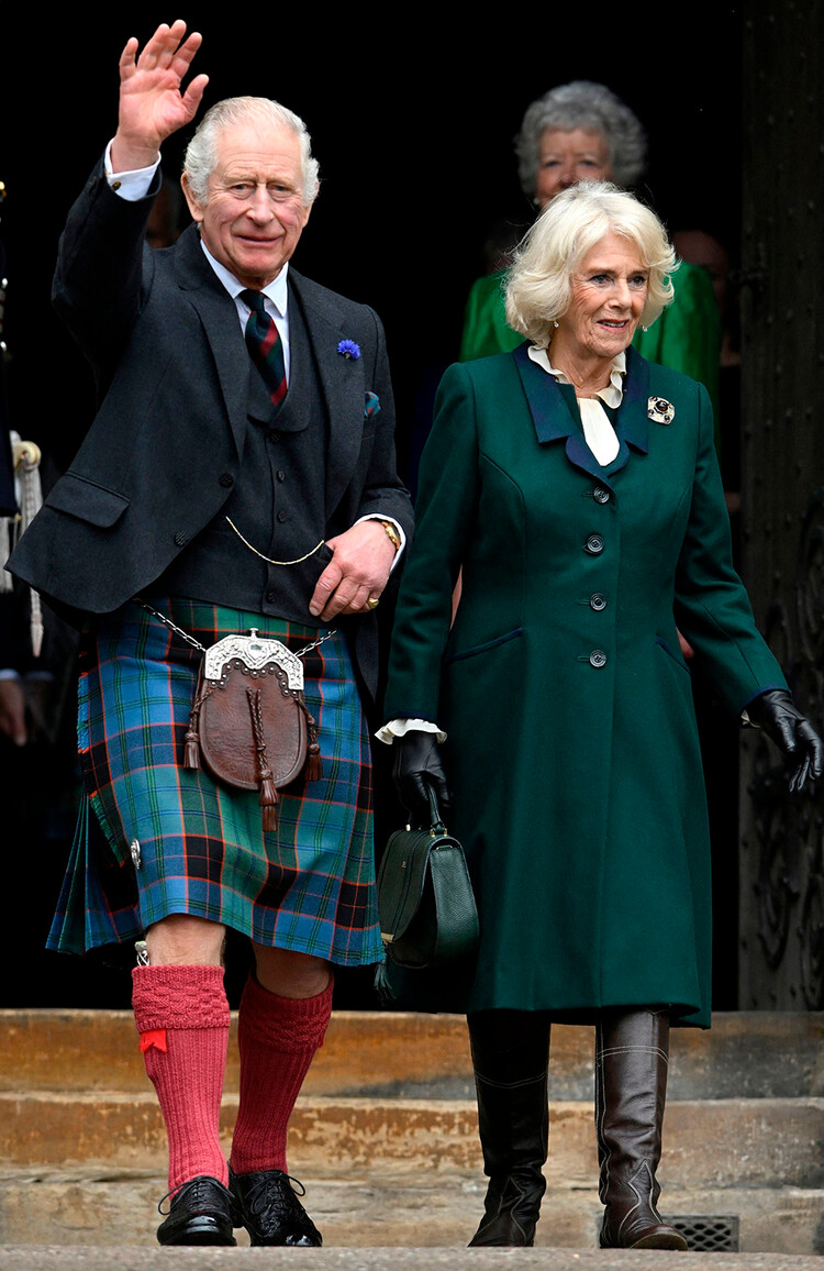 Король Карл III с Камиллой, королевой-консорт машут рукой, направляясь навстречу к представителям общественности после выхода из Данфермлинского аббатства в Данфермлине на юго-востоке Шотландии 3 октября 2022 года