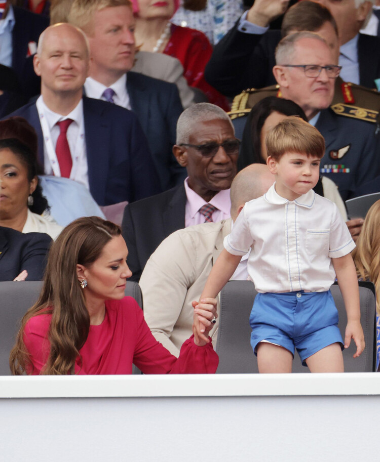 Кейт Миддлтон держит младшего сына принца Луи за руку, во время его бурной реакции на театрализованное представление платинового юбилея королевы, 5 июня 2022 года в Лондоне, Англия