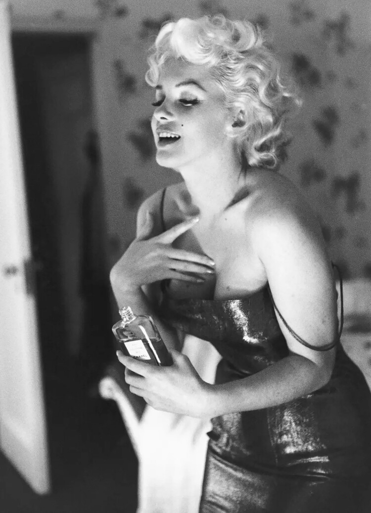 Мэрилин Монро игриво нанося макияж и духи Chanel № 5 24 марта 1955 года в Нью-Йорке