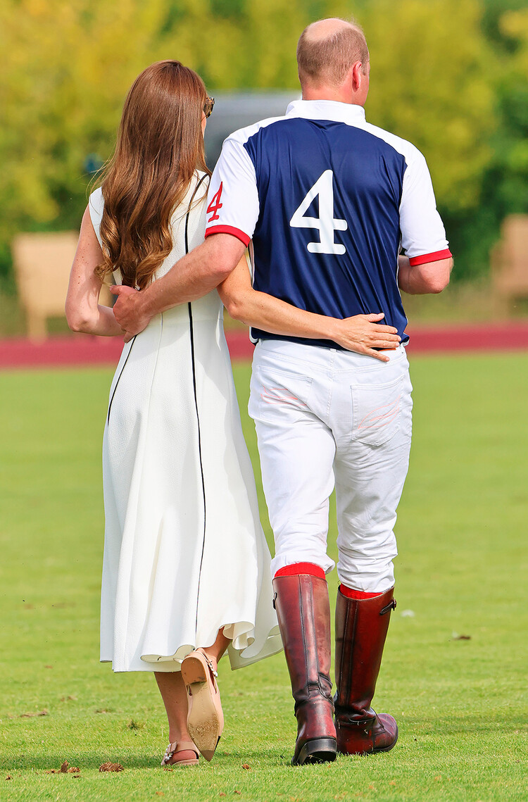 Принц Уильям целует Кейт Миддлтон идут по полю в клубе Guards Polo Club 6 июля 2022 года в Эгаме, Англия