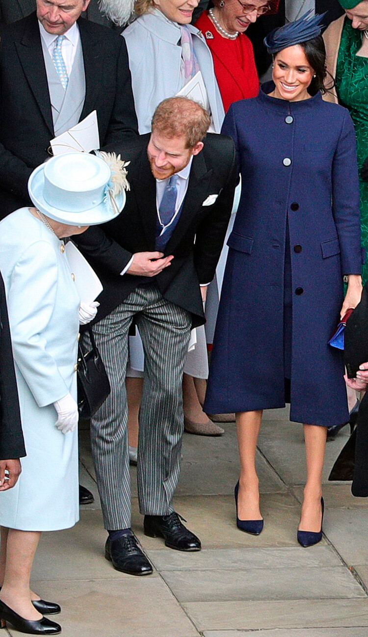 Королева Елизавета II беседует с принцем Гарри и Меган Маркл после свадьбы принцессы Евгении Йоркской с Джеком Бруксбэнком в часовне Святого Георгия в Виндзорском замке, 12 октября 2018 года