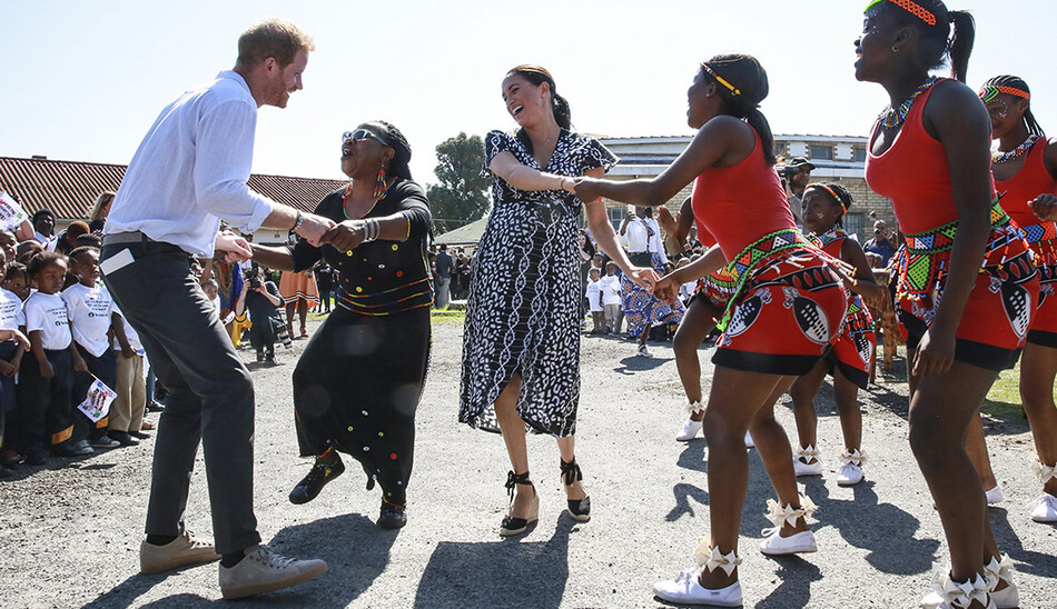 Меган, герцогиня Сассекская, танцует вместе с герцогом Сассекским, во время их королевского турне по Южной Африке 23 сентября 2019 года в Кейптауне, Южная Африка. 