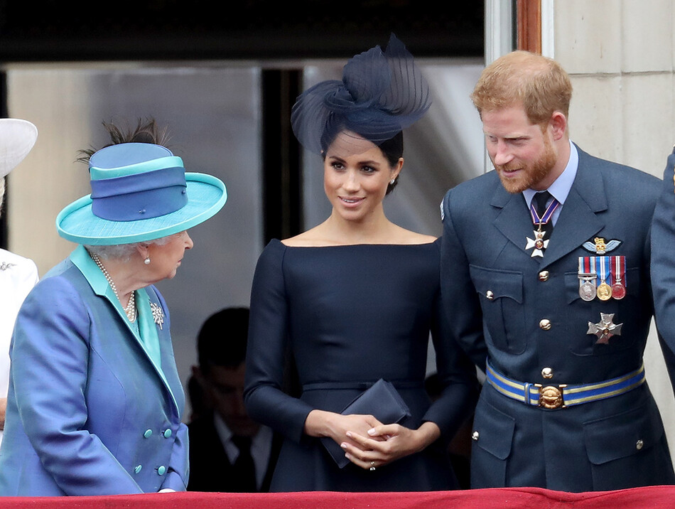 Елизавета II, Меган Маркл и принц Гарри беседует на балконе Букингемского дворца во время парада, приуроченного к 100-летию Королевских ВВС, 10 июля 2018 года в Лондоне, Англия