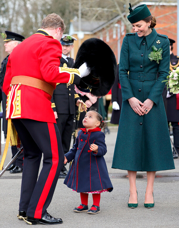 Кэтрин, герцогиня Кембриджская смотрит как подполковник Роб Мани надевает медвежью шапку на голову своей дочери Гайи Мани во время Парада в честь Дня Святого Патрика в Олдершоте, Англия