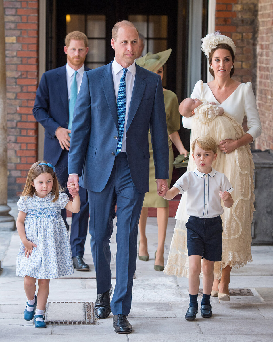 Принцесса Шарлотта и принц Джордж держатся за руки своего отца, принца Уильяма, герцога Кембриджского, во время прибытия в Королевскую часовню Сент-Джеймсского дворца в Лондоне для крестин своего брата, принца Луи, который их мать, Кэтрин, герцогиня Кембриджская, несет их мать 9 июля 2018 года в Лондоне, Англия