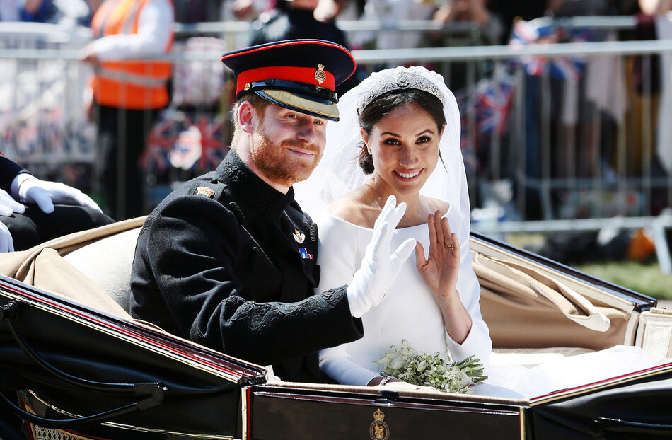 Принц Гарри и его новая невеста Меган Маркл едут по свадебному маршруту на Хай-стрит за пределами собора Святого Георгия, 19 мая 2018 года, в день их свадьбы в Виндзоре, Великобритания