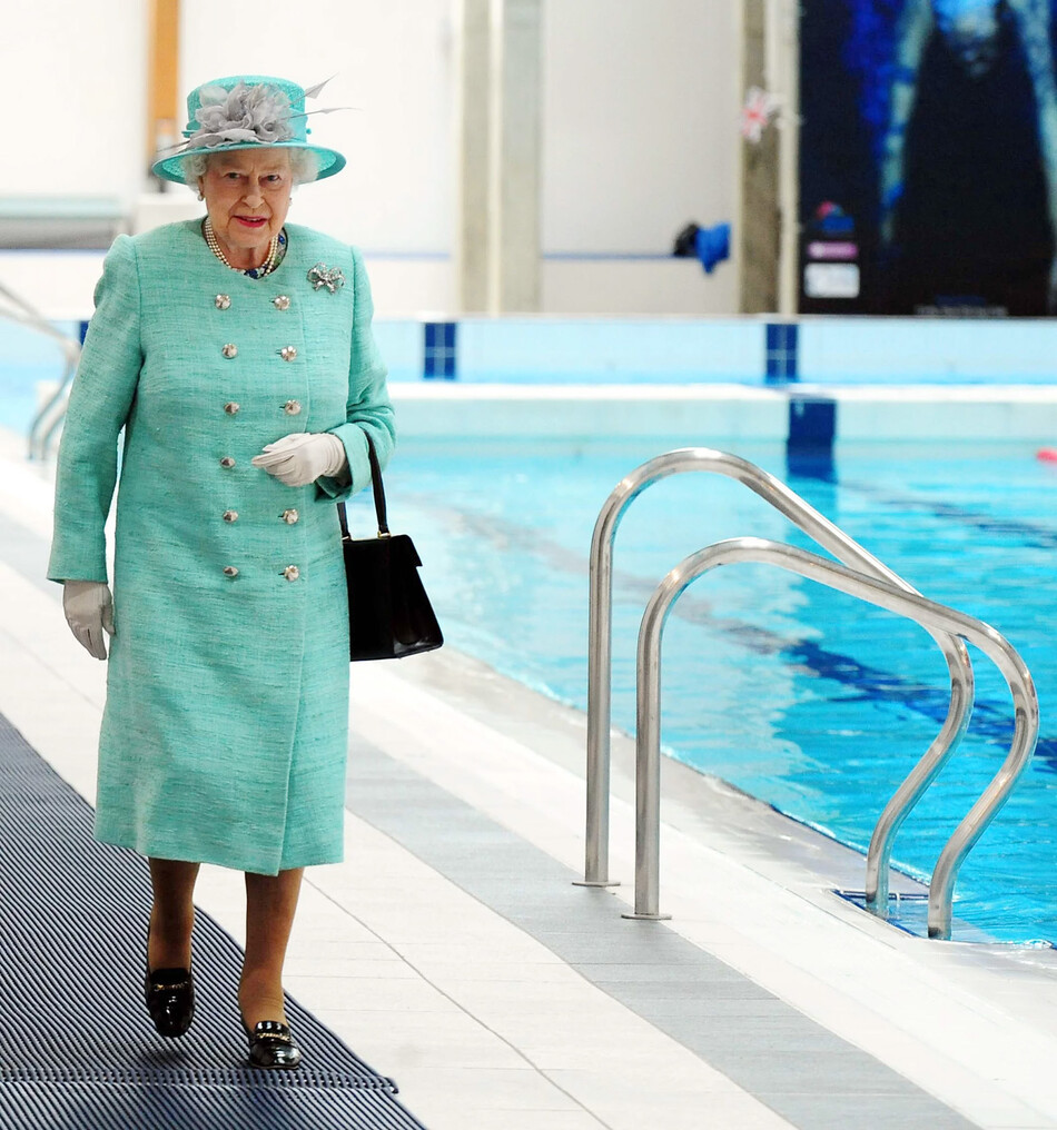 Королева Елизавета II идёт вдоль олимпийского бассейна в Корби во время своего бриллиантового юбилейного тура по Ист-Мидлендсу, 13 июня 2012 года