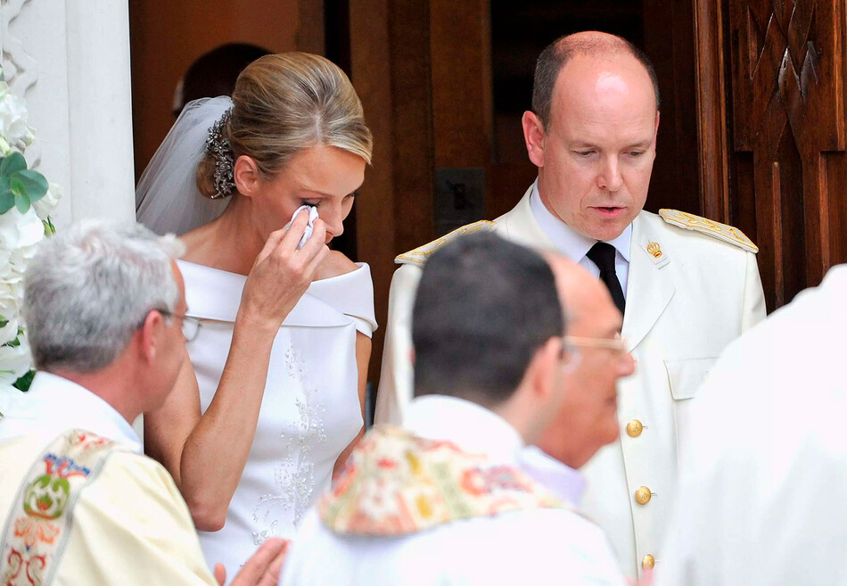 Принцесса Монако Шарлен вытирает слезу, когда она и принц Монако Альберт II покидают церковь Sainte Devote после свадебной церемонии в Княжеском дворце Монако 2 июля 2011 года в Монако