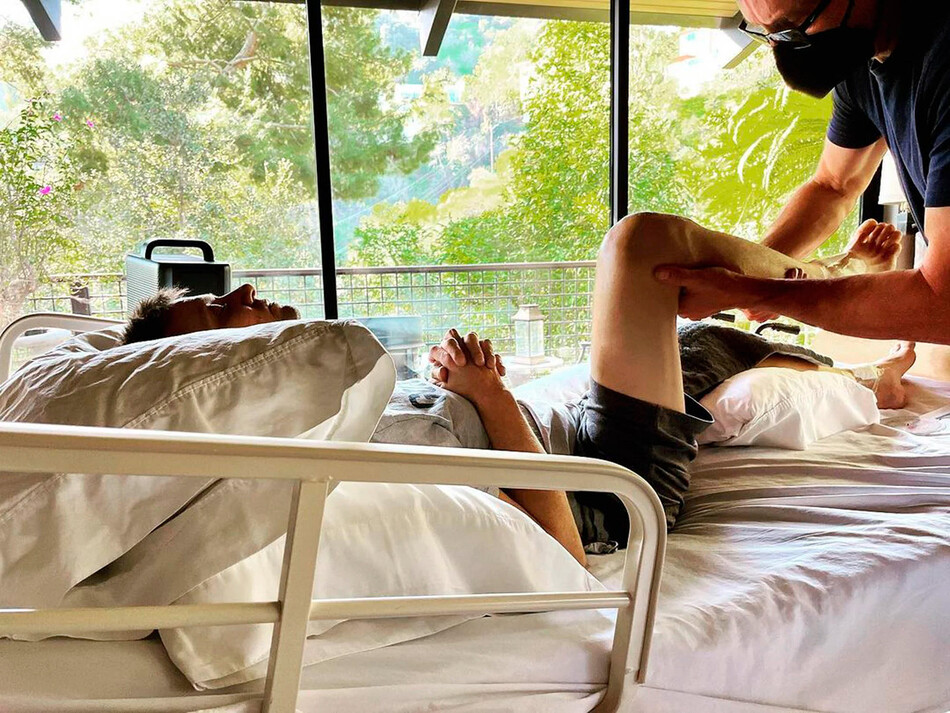 Джереми Реннер&nbsp;на больничной койке с врачом, разминающим его ногу