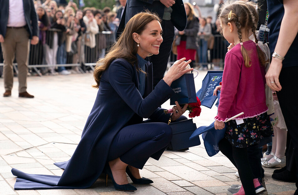 Кэтрин, герцогиню Кембриджскую дарит подарок маленькой девочке во время визита в Университет Глазго 11 мая 2022 года в Глазго, Шотландия