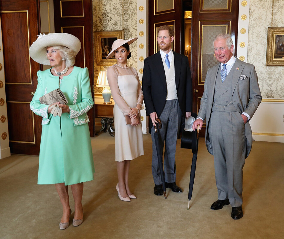 Король Карл III и королева-консорт Камилла Паркер-Боулз вместе с Меган Маркл и принцем Гарри во время благотворительного приёма в садах Букингемского дворца в честь 70-летия принца Уэльского, 22 мая 2018 года, Лондон, Великобритания
