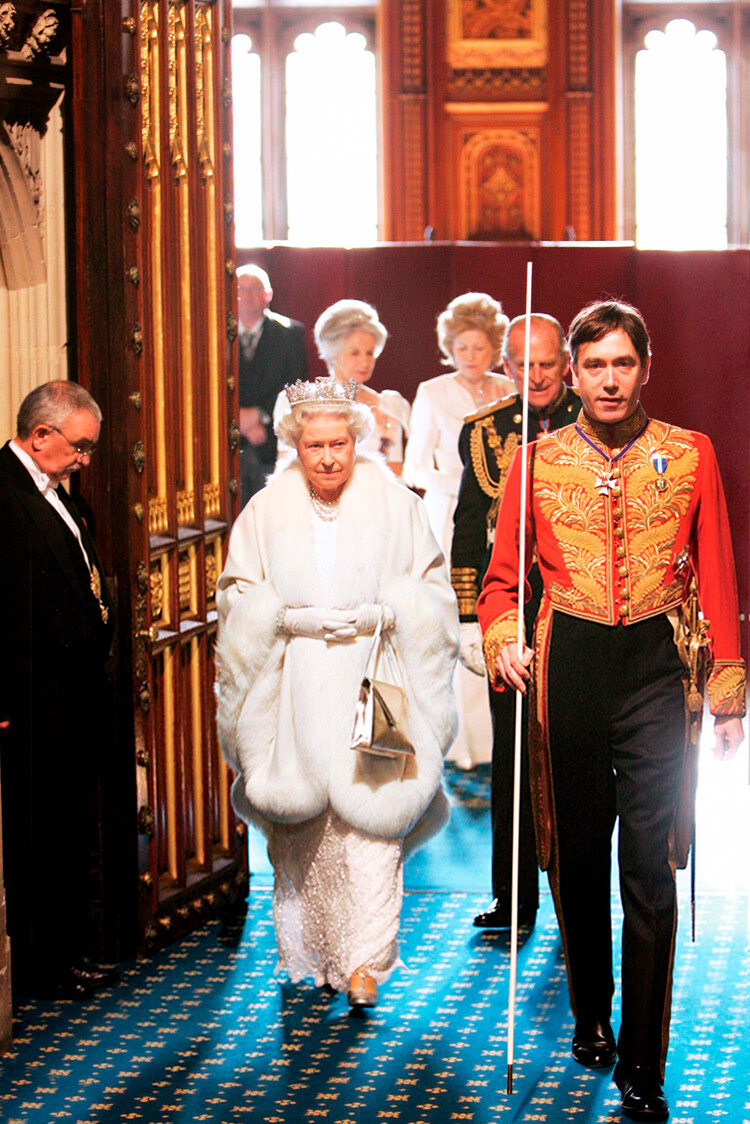 Королева Елизавета II и принц Филипп, герцог Эдинбургский, следуют за лордом Великим Чемберленом, маркизом Чолмондели (справа), во время прибытия в Палату лордов на открытие парламента 6 ноября 2007 года в Лондоне, Англия