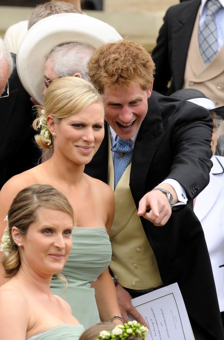 Зара Филлипс разговаривает с принцем Гарри во время свадьбы её брата Питера Филлипса, 30 лет, и Отэм Келли, 31 года, в часовне Святого Георгия в Виндзоре 17 мая 2008 года