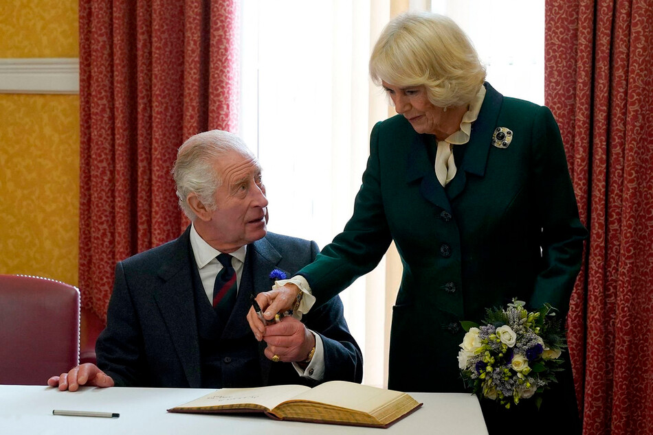 Король Карл III с Камиллой, королевой-консорт вместе подписывают книгу посетителей после посещения официального заседания совета в городской палате в Данфермлине, 3 октября 2022 года Шотландия