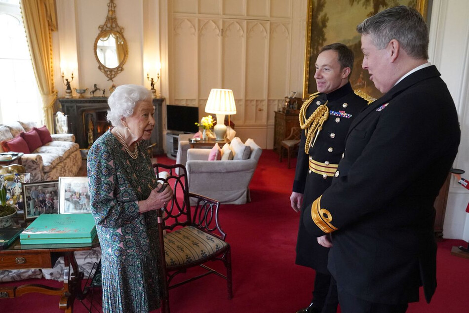 Королева Елизавета II беседует с контр-адмиралом Джеймсом Маклеодом и генерал-майором Элдоном Милларом (справа) в Виндзорском замке 16 февраля 2022 года в Виндзоре, Англия