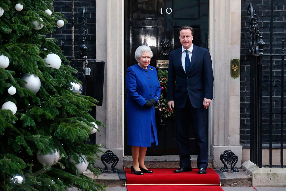 Премьер-министр Великобритании Дэвид Кэмерон (справа) приветствует Её Величество Королеву Елизавету II, когда она прибывает на Даунинг-стрит, 10, для участия в еженедельном заседании кабинета министров 18 декабря 2012 года в Лондоне, Англия