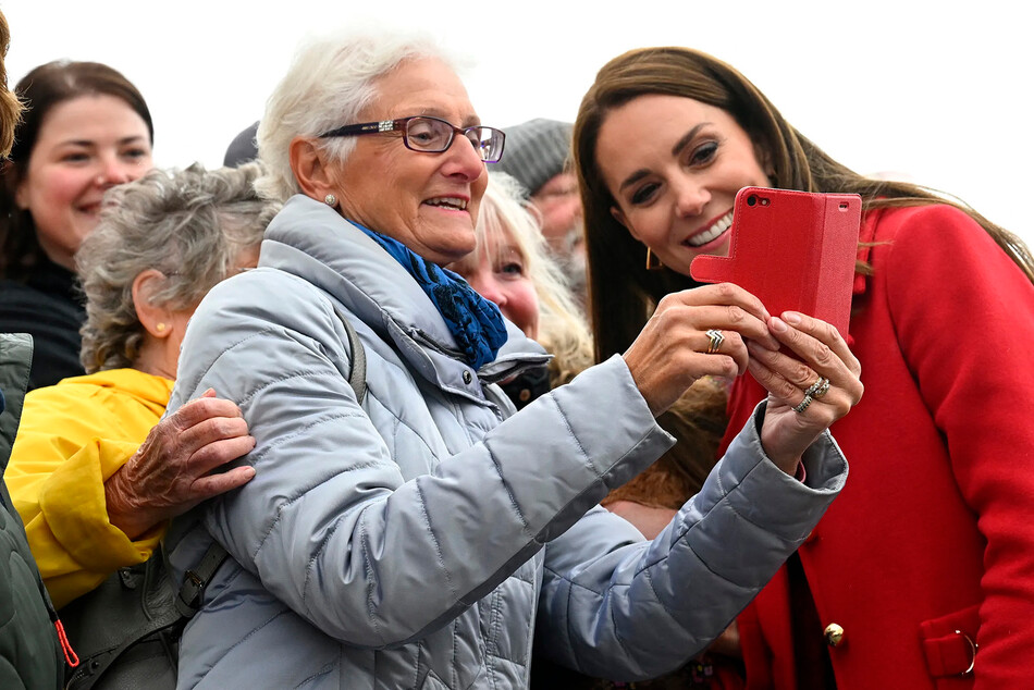 Кэтрин, принцесса Уэльская делает селфи с жителем Холихеда во время визита на спасательную станцию RNLI Holyhead, 27 сентября 2022 г., Уэльс